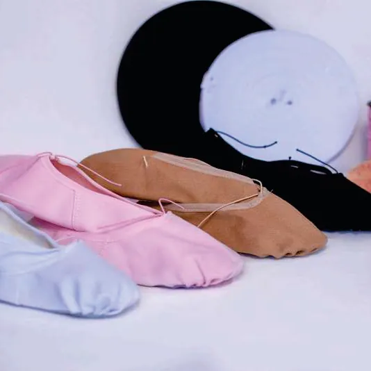 Sapatilhas de balé nas cores rosa, salmão, branca e preta dispostas lado a lado.